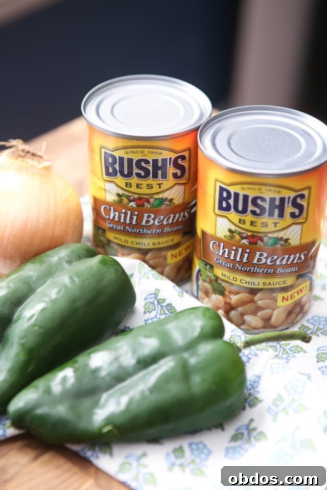 Δύο κονσέρβες Bush's chili beans, ένα λευκό κρεμμύδι και δύο πιπεριές poblano.