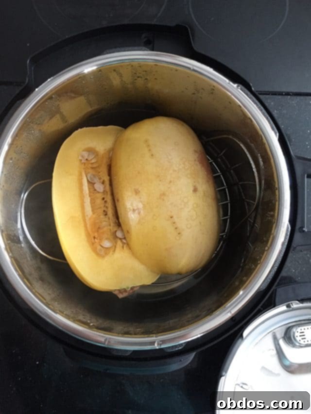 Δύο μισά κολοκύθας σπαγγέτι σε ένα μπολ Instant Pot πριν το μαγείρεμα, έτοιμα για τοποθέτηση