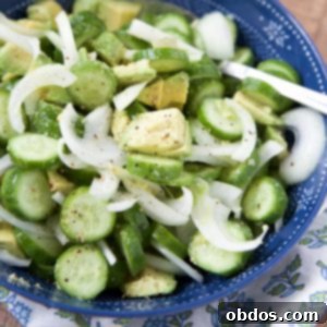 Κοντινή λήψη αγγουροσαλάτας με αβοκάντο και κρεμμύδι σε μπλε μπολ